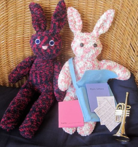Inside her satchel, this bunny has a trumpet, some sheet music and a pink notebook.